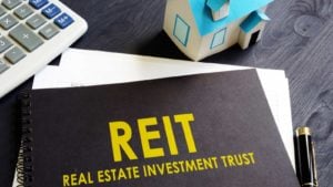 Real estate investment trust (REIT) on a black notebook on an office desk.