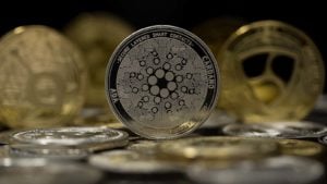 The Cardano token with other gold and silver tokens in the background.