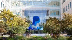 PayPal (PYPL) logo overlays daylight photo of corporate building