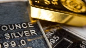 Close-up of a gold-ingot on top of a troy ounce silver and palladium bar. Precious metals. Gold, silver, palladium.