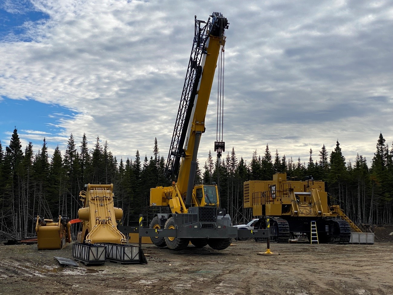 Caterpillar 6020 shovel (top) and two Caterpillar 777 100t mine trucks undergoing on-site preparation (bottom)