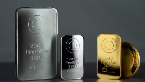 Gold and silver bars in front of a grey background.
