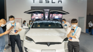 Tesla (TSLA) model X displayed in China auto expo during covid19 pandemic. Staff wearing face mask.