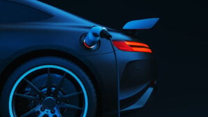 Illustration of blue electric vehicle (EV) charging with dark black background. EV Stock