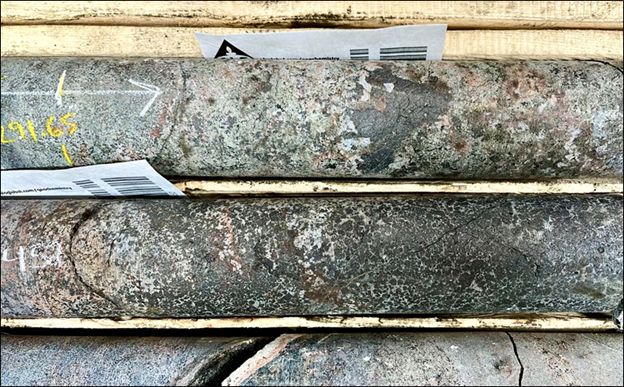 West of Pike Zone.  Photograph of drill core with 3.3% TREO at 291.65 m in drill hole HK22-017 located half a kilometer southwest of Pike Zone.  The high grade TREO occurs towards the end of an overall intersection of 287 m of continuous TREO + Nb mineralization. The drill hole is located on a RTP magnetic anomaly 200 x 700 m in size.  The core shows aggregates of magnetite in a near total calc-potassic fenite replacement of the host rock by calcite, apatite, REE minerals (monazite & bastnaesite), and amphibole.