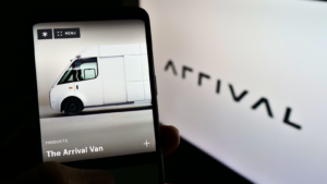 Person holding cellphone with webpage of electric vehicle manufacturer Arrival Ltd (ARVL) on screen in front of logo. Focus on center of phone display. Unmodified photo.