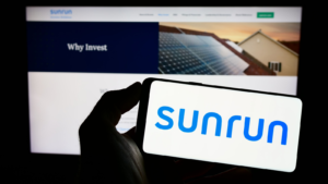 Person holding cellphone with logo of U.S. solar energy company Sunrun Inc. (RUN) on screen in front of business webpage. Focus on phone display.